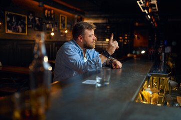 Bearded man sitting at the counter in bar