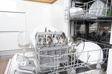 Dishes and cutlery on dishwashing machine. Clean dishes