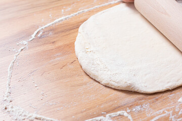 Rolling pin and dough. Woman preparing dough