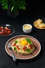 Traditional Italian Pasta Carbonara with bacon, cheese and egg yolk on plate on dark background