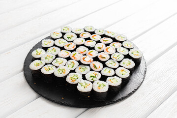 Set of sushi rolls on black plate