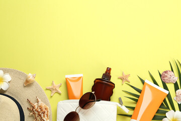 Sun protection products and beach accessories on yellow background, flat lay. Space for text