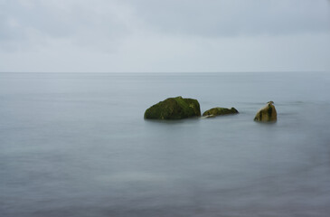 Fototapeta na wymiar long exposure of rocks in the sea