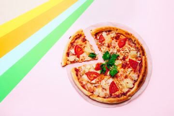 Top view with a sliced pizza on a colored background.