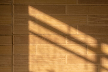 Abstract background with light falling on a tiled beige wall.