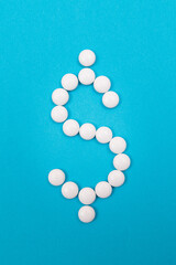 Global Pharmaceutical Industry and Medicine Business - Dollar Symbol Made from White Pills Lying on Blue Background