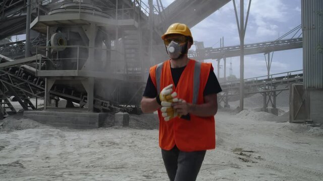 Male quarry worker removing protective gear