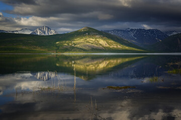 Mirror image on a mountain lake on a spring morning
