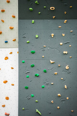 Abstract colorful of rock climbing wall with toe and hand hold studs, various colored grips at outdoor gym adventure park.