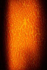 Orange textured wall with cracks and unusual curves with a vignette vertical orientation