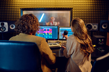 Musicians at mixing console, recording studio