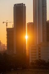 Sun setting behind high rise skyscrapers under construction in the suburb of Kandivali in the city of Mumbai.
