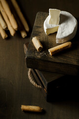 brie and grissini cheese on a wooden background