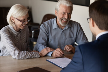 Happy mature family couple of clients consulting legal expert, lawyer, solicitor about legal document signing, asking advice, question, talking, celebrating deal, house or medical insurance buying