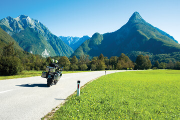 Two person with baggage riding motorbike towards the mountains