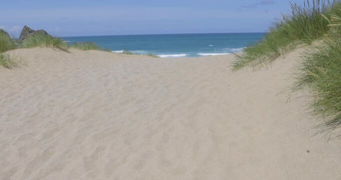 Seaside scene with sand dunes and waves in Cornwall