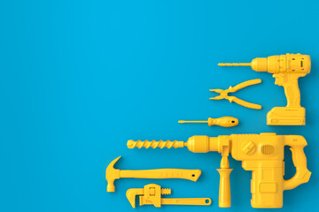 Top view of monochrome construction tools for repair on blue and yellow