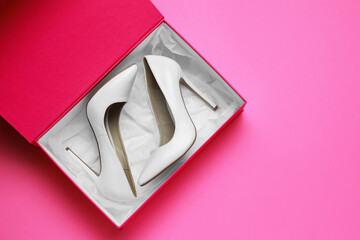 Stylish women's shoes in cardboard box on pink background, top view. Space for text