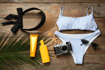 Flat lay composition with beach accessories on wooden background