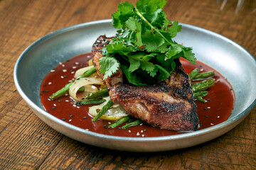 Grilled chicken wings with white barbecue sauce ponzu cucumbers and sauce in a plate on a wooden background