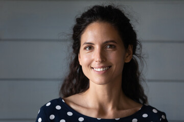 Portrait of happy pretty Hispanic 30s woman with black wavy hair looking at camera. Beautiful...