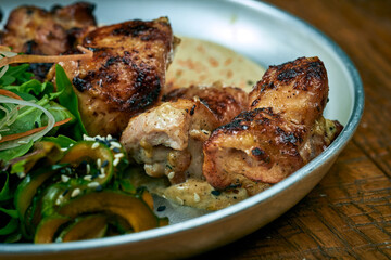Grilled beef with white barbecue sauce ponzu cucumbers and sauce in a plate on a wooden background