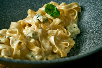 Cheese creamy fettuccine pasta in a gray plate. Italian cuisine