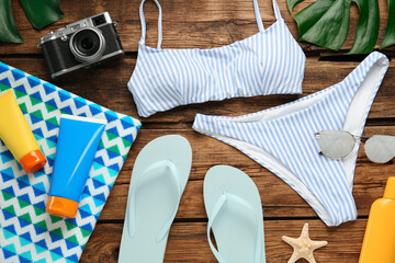 Different beach objects on wooden background, flat lay