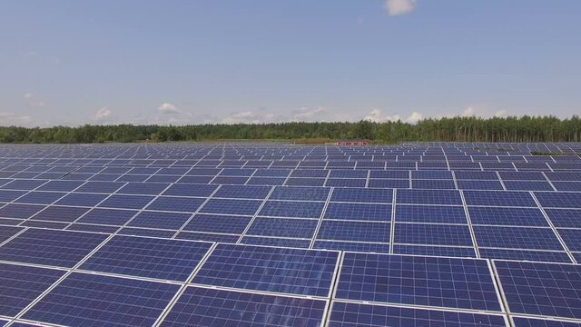 Aerial footage of hundreds solar energy modules or panels rows
