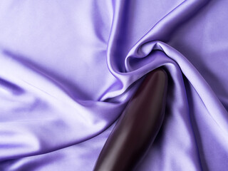 Sexy concept with eggplant on purple crumpled silk sheet