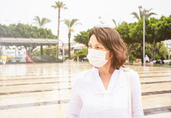 Fototapeta na wymiar Portrait of a vacationing woman in a protective mask travels after quarantine
