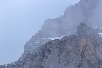 The peak of a mountain cliff in the fog
