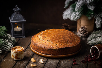 Traditional Christmas cake pudding with fruits and nuts with Christmas decorations, dark background