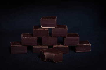 dark dark chocolate cubes on a black background