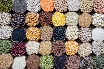 Variety kinds of natural organic cereal and grain seed in dry banana leaf bowl on wooden background. For natural or healthy food ingredient or agricultural product concept