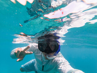 Man snorkeling underwater. Blue clear water. Copy space. Concept of travel and vacation 