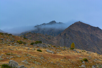 Mountains in the fog. Fall. Overcast. Ile-Alatau mountains, Almaty region, Kazakhstan.