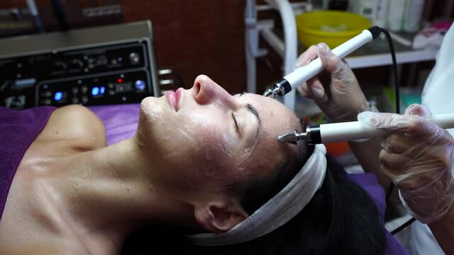 Cosmetologist dong the procedure of microcurrent therapy. beautician procedure for facial.