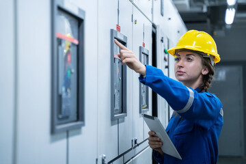 Woman Electrical Engineer working front HVAC control panels, Technician daily check solar cell controls system for security functions in service room at factory.Energy,Ventilation,Air Conditioning.