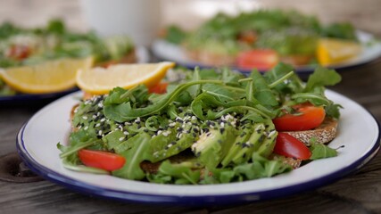 Serving a plate of healthy delicious organic gluten free avocado toast. Vegan breakfast concept