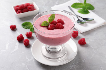 Delicious raspberry mousse with mint on grey marble table
