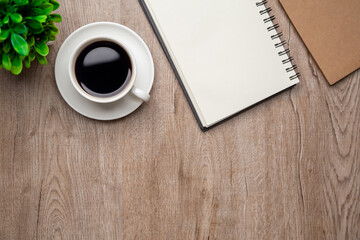 Flat lay, top view office table desk. Workspace with, laptop,office supplies, pencil, green leaf, and coffee cup on wood background.