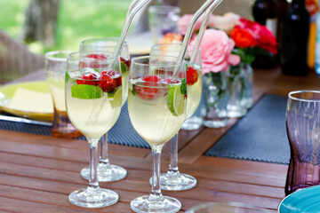 Cocktail Hugo with elderflowers, strawberries, lime and mint. Fresh summer barbecue drink for parties.