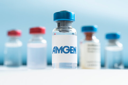 Vials of liquid on a white table and the logo of a large pharmaceutical company.