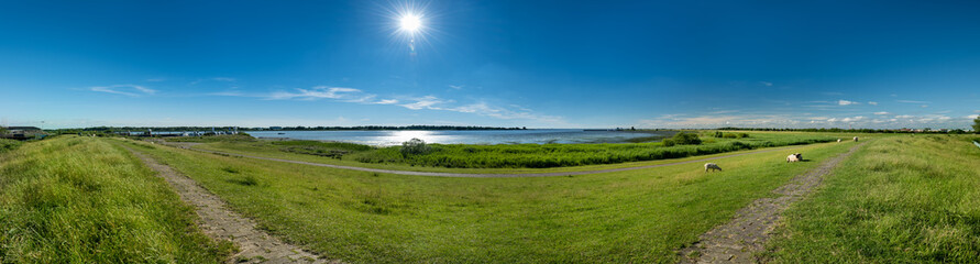 Glückstadt, Germany. The river Elbe with dike and marshland. Panoramic view.