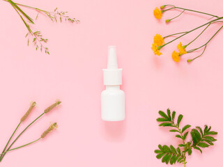 A mock-up of a nasal spray and various field plants on a pink background. The concept of means of...