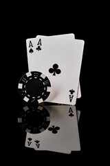 Casino chips and playing cards on dark reflective background