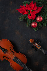 Old violin and fir-tree branches with Christmas decor and poinsettia.  Christmas and New Year's...