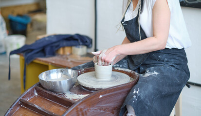 Female Potter creating a earthen jar on a Potter's wheel