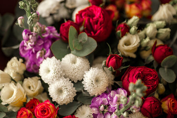 Top view of beautiful colorful bouquet. Fresh white, red, purple and orange flowers background. Сombination of white chrysanthemums, purple delphinium and red peony roses.